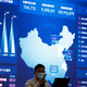 A man stands in front of a large screen showing analytics data about the Chinese web at an internet fair in Beijing in April 2021; used here as stock photo.